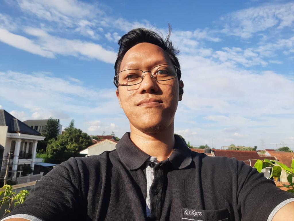 Foto Nugi dengan latar belakang langit biru