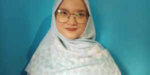 foto Ayu Ningsih menggunakan hijab putih dengan background biru